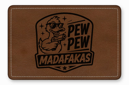 Brown rectangular leather patch stamped with a duck wearing sunglasses and holding a gun, accompanied by the text PEW PEW MADAFAKAS.