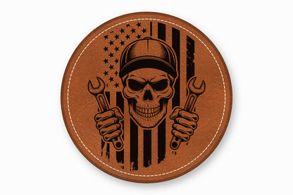 Round brown leather patch featuring a skull in a cap holding wrenches before an American flag.