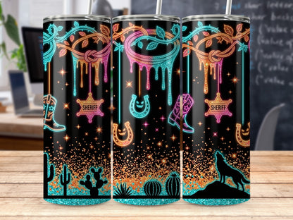 Three tumblers with neon western designs featuring boots, sheriff badges, horseshoes, and wolves.