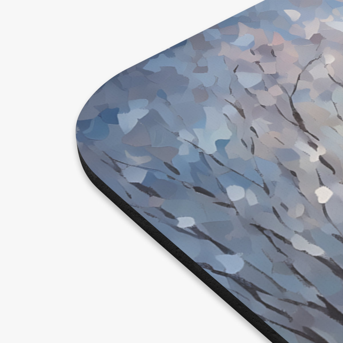 Abstract winter tree branches and blue brushstrokes on a mousepad.