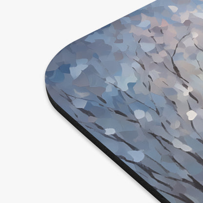 Abstract winter tree branches and blue brushstrokes on a mousepad.