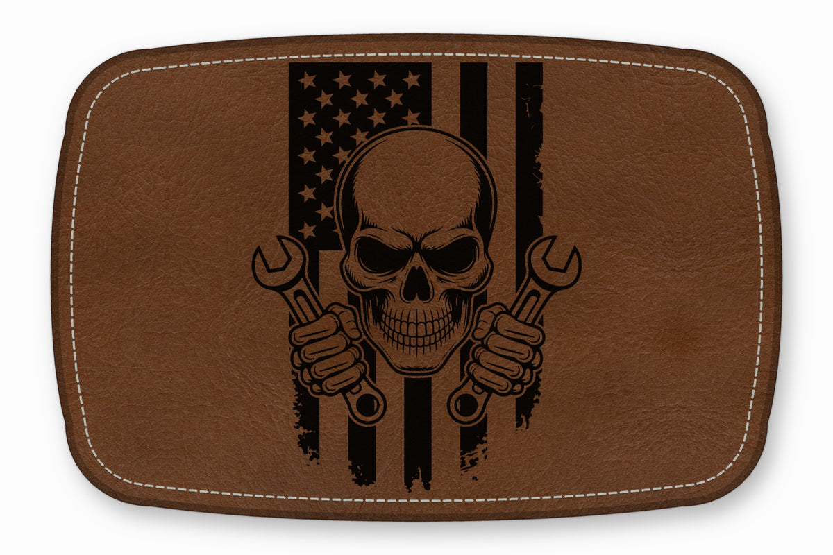 Brown leather patch featuring a black skull holding wrenches in front of an American flag.