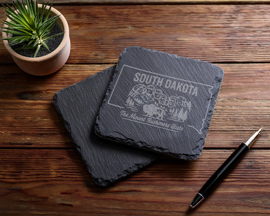 South Dakota coasters engraved with Mount Rushmore and a bison.