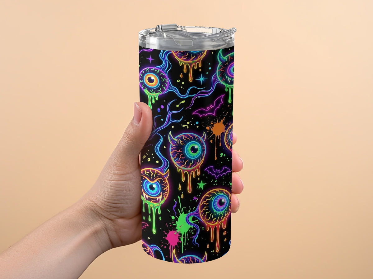 Tumbler with dripping eyeballs, bats, and neon splatters on black background.