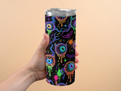 Tumbler with dripping eyeballs, bats, and neon splatters on black background.