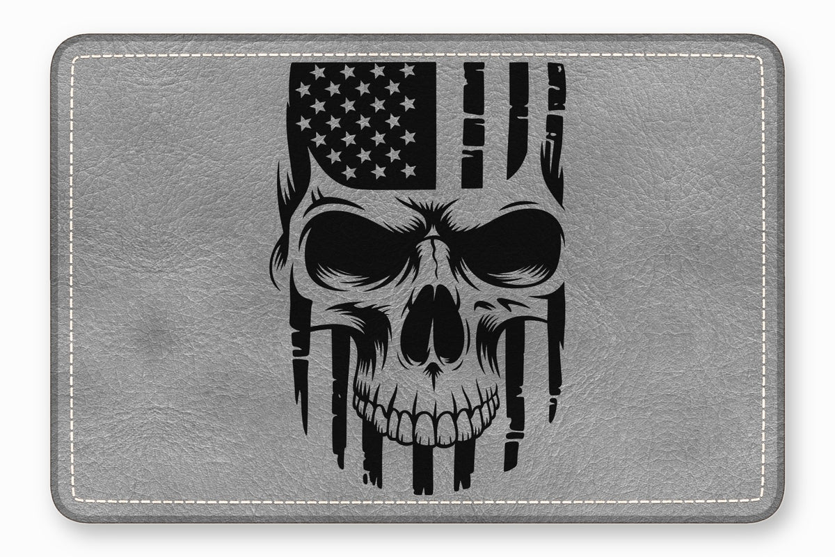 A grey rectangular leather patch features a black graphic combining a human skull with the American flag.