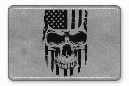 A grey rectangular leather patch features a black graphic combining a human skull with the American flag.