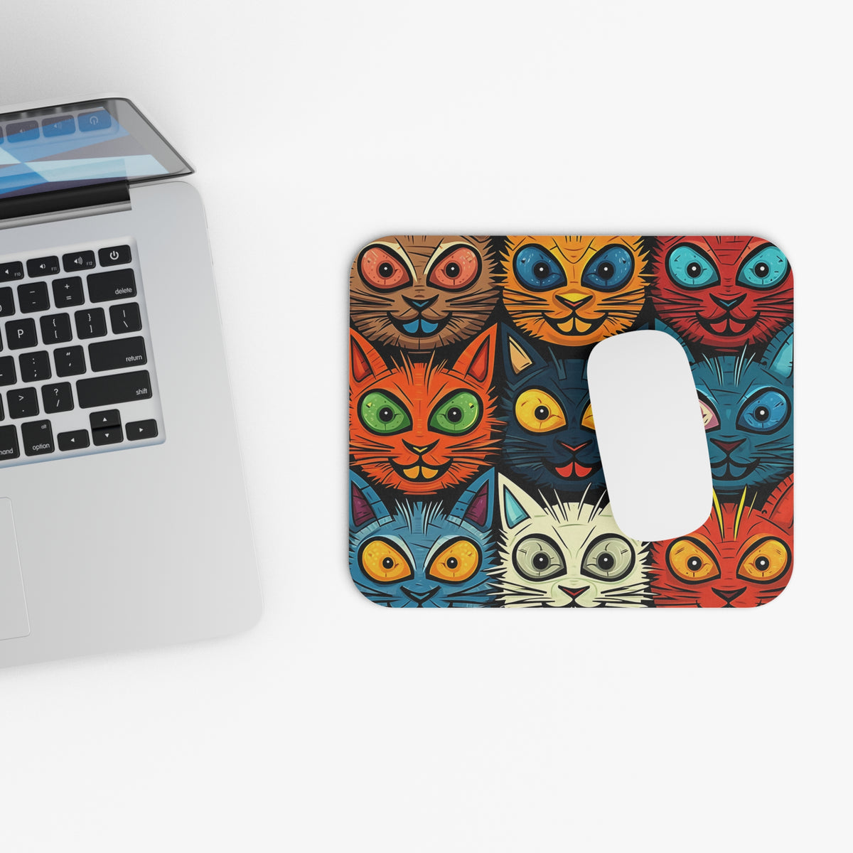 Mousepad with a colorful pattern of cartoon cat faces in a grid layout.