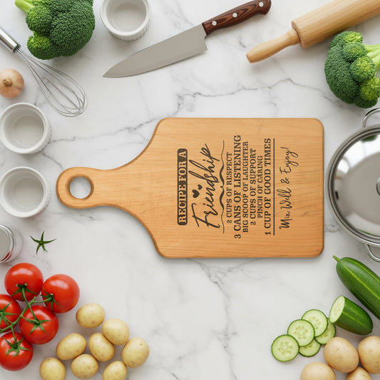 Wooden cutting board with "Recipe for a Friendship" engraved on it.