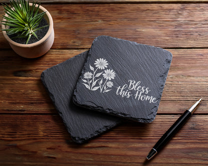 Two slate coasters with floral design and "Bless this Home" text.