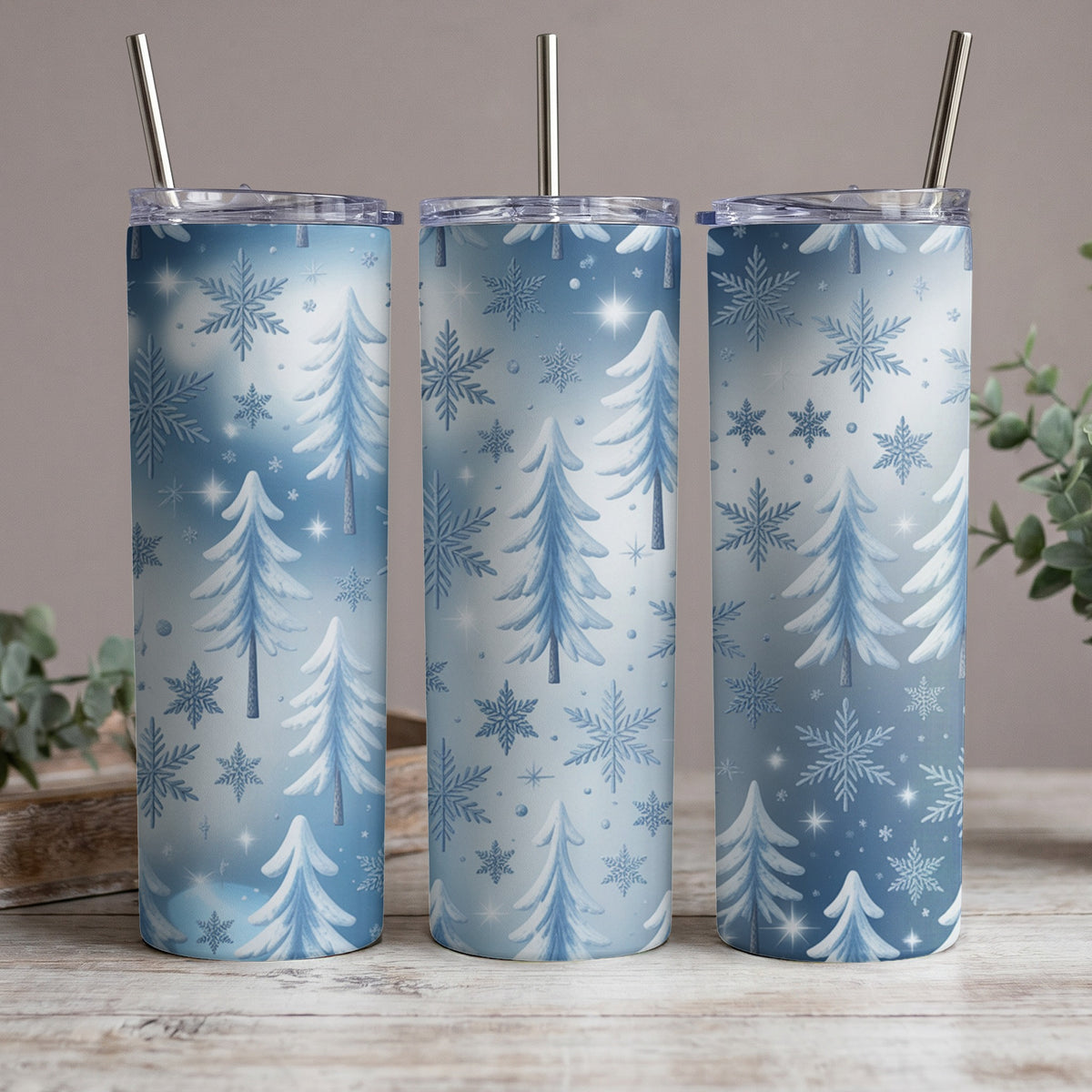 Three tumblers with a winter forest and snowflake pattern, each with a metal straw.