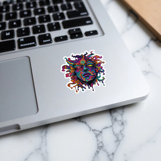 Colorful melting sun face sticker on a silver laptop keyboard.