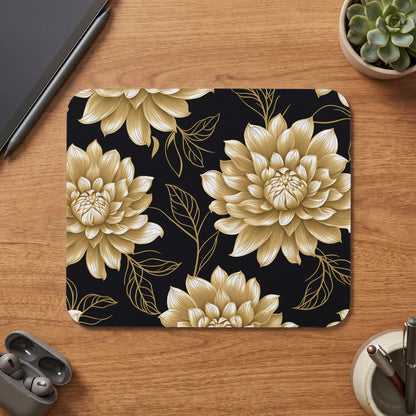 Mousepad with gold floral pattern on black background on a wooden desk.