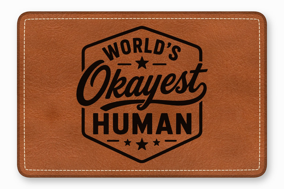 Brown leather patch with white stitched border and black text reading World's Okayest Human inside a badge.