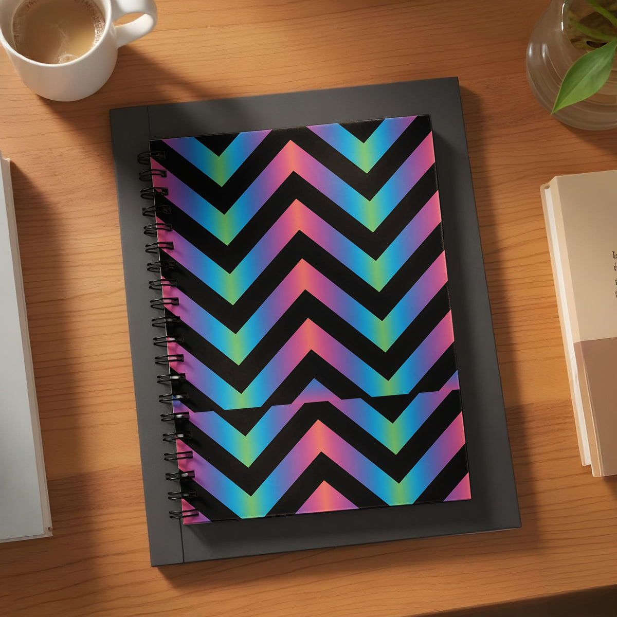 Spiral notebook with black background and iridescent chevron pattern.