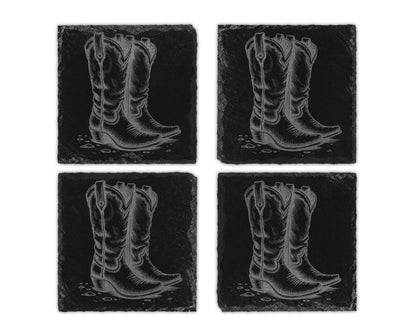 Four slate coasters with etched designs of cowboy boots on black backgrounds.