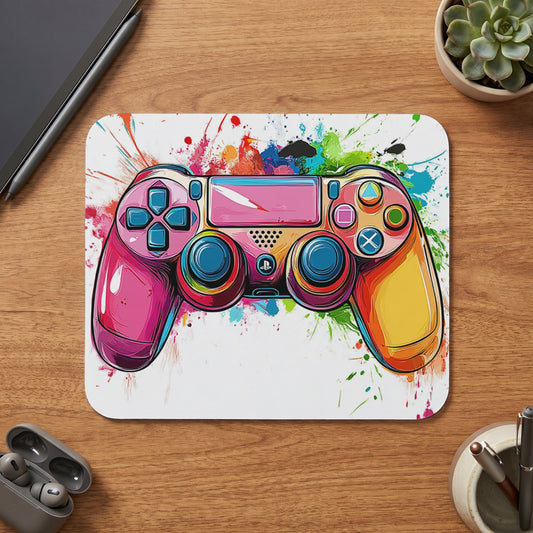 Colorful video game controller on a white mousepad with paint splatters.