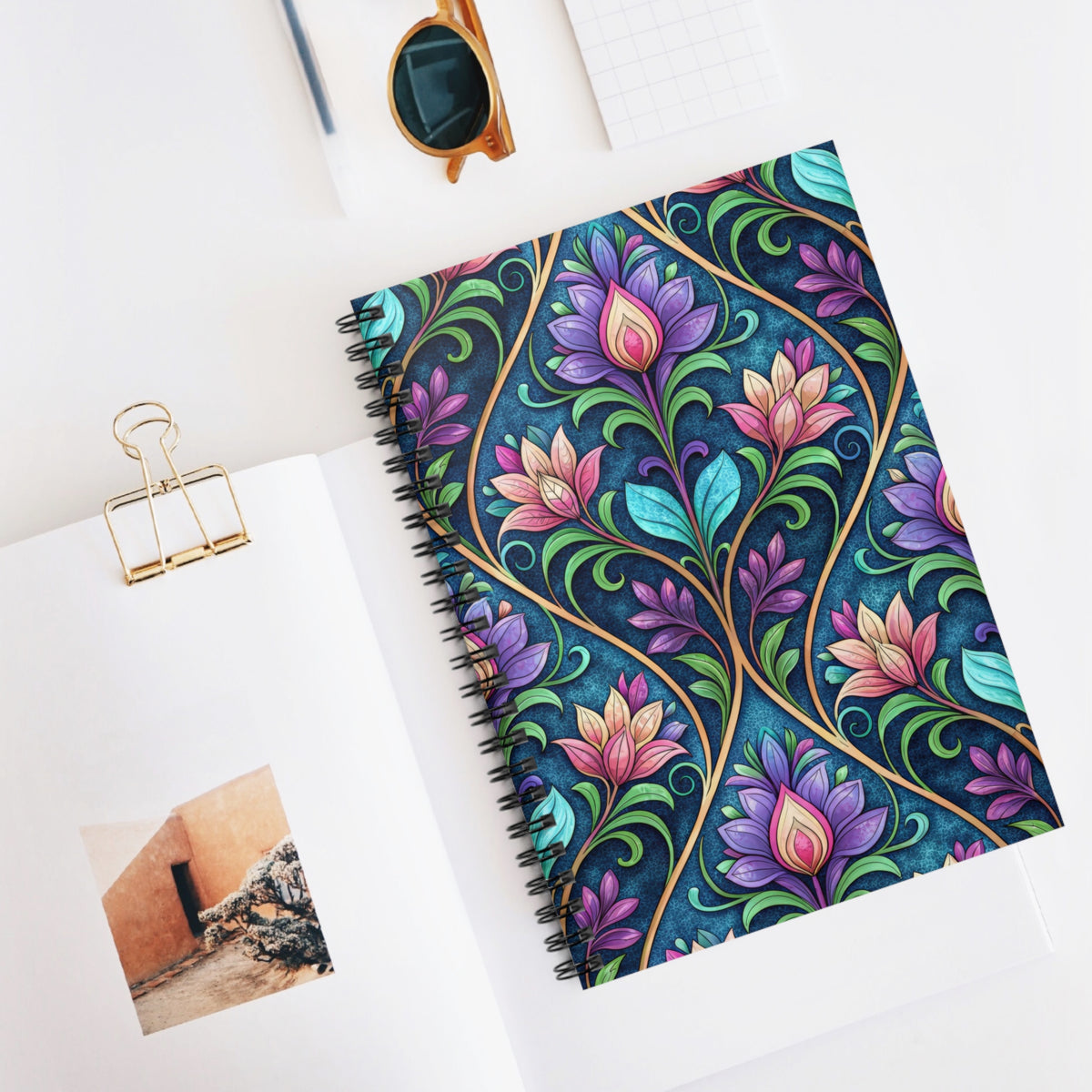 Spiral notebook with colorful floral art nouveau design on navy background.