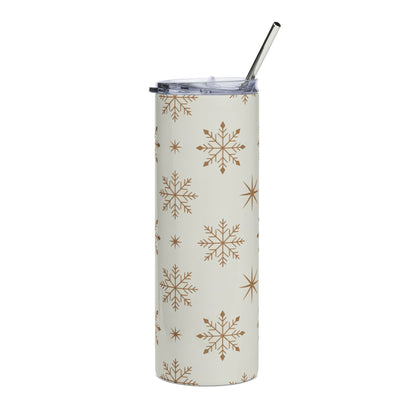 Tall tumbler with a beige background and brown snowflake pattern and a metal straw.