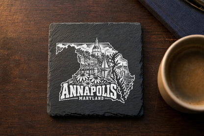Square black slate coaster engraved with a white Annapolis, Maryland skyline design on a wooden table.