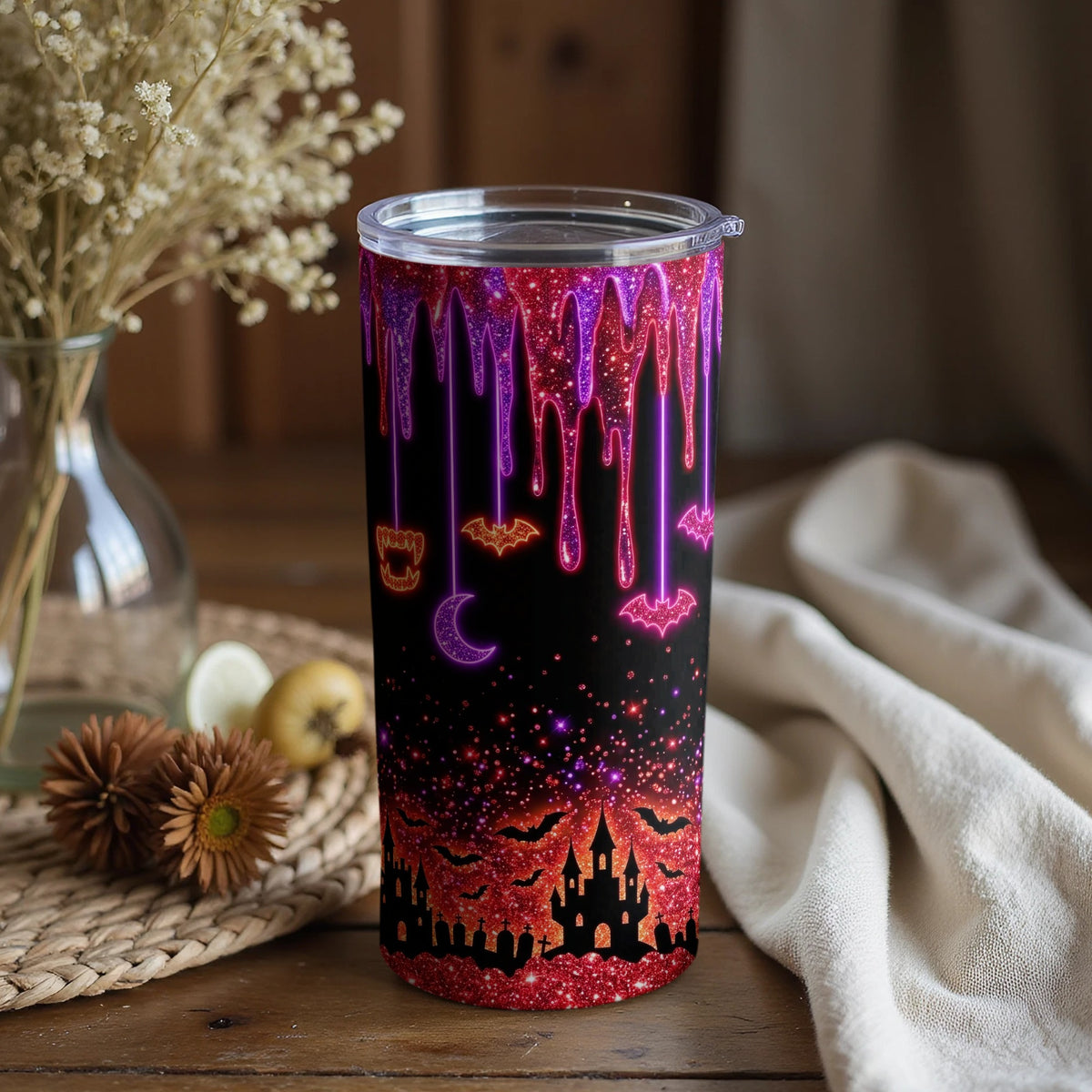 Tumbler with dripping glitter design featuring bats, moon, castle, and gravestones.