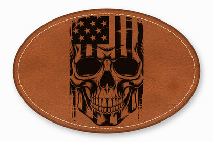 An oval brown leather patch with white stitched edges features a black distressed skull and American flag design.