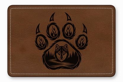 Brown leather patch with rounded corners and white border stitching featuring a laser-engraved wolf and bear paw design.