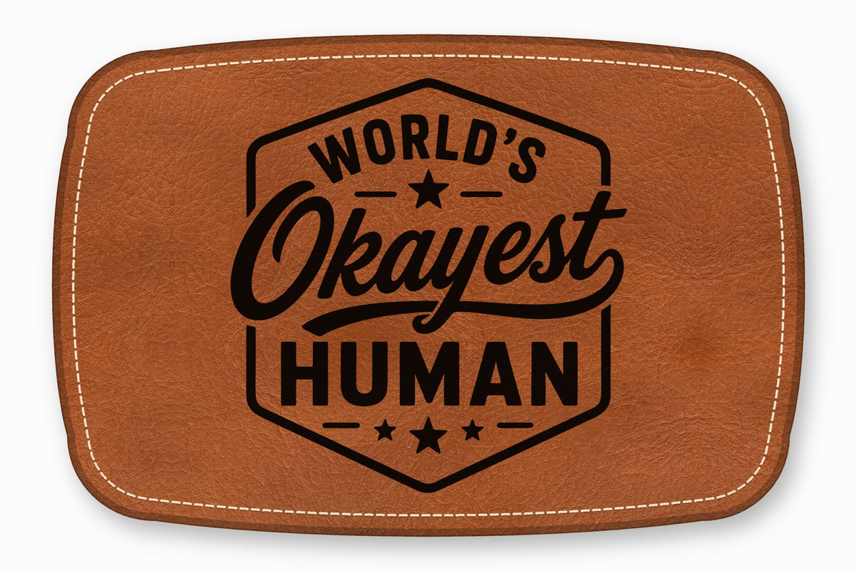 Brown leather patch with white stitching and the text World's Okayest Human inside a hexagon.