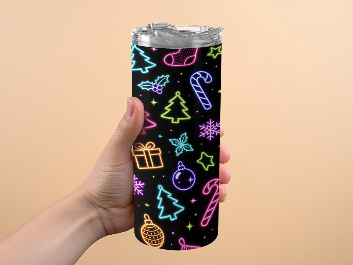 Hand holding tumbler with neon Christmas pattern on black background.
