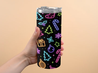 Hand holding tumbler with neon Christmas pattern on black background.