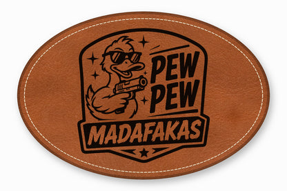 Brown oval leather patch featuring a duck wearing sunglasses, holding a gun, and text reading PEW PEW MADAFAKAS.