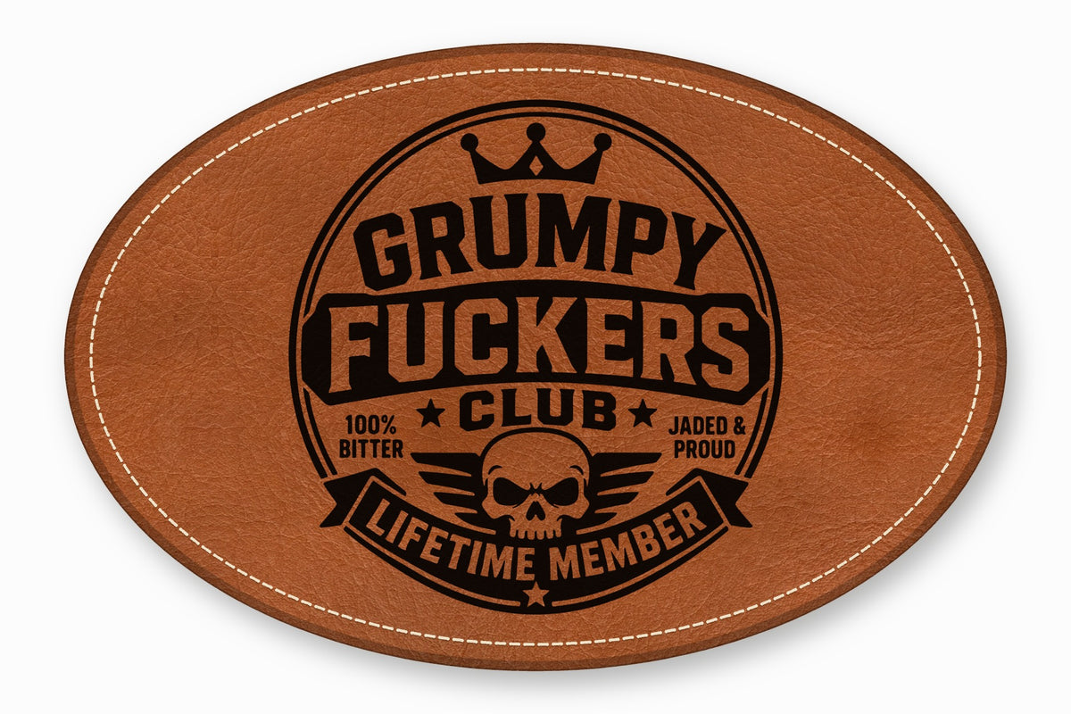 Oval brown leather patch with white stitched border and black debossed text reading Grumpy Fuckers Club.
