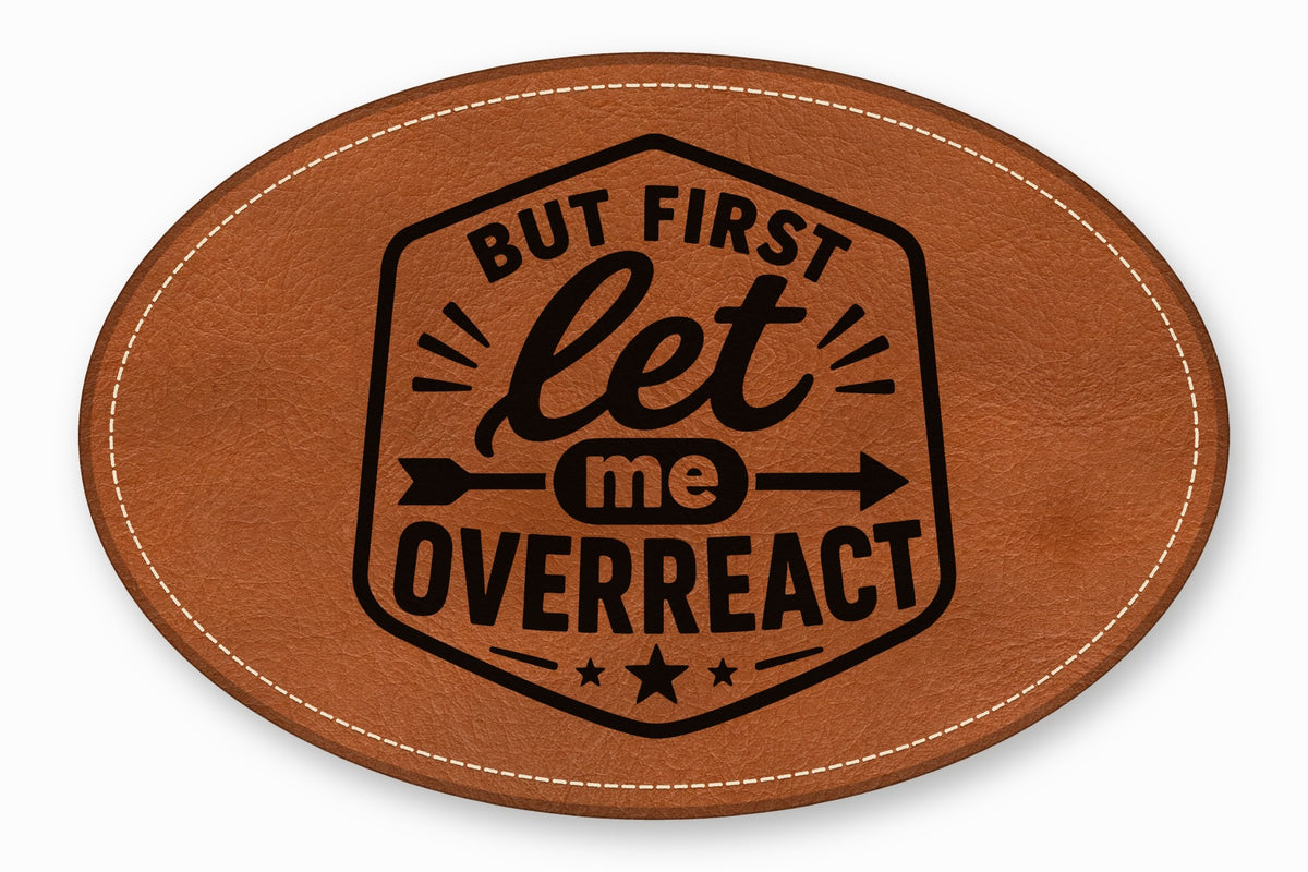 Brown oval leather patch with white stitched border and black text reading But First Let Me Overreact.