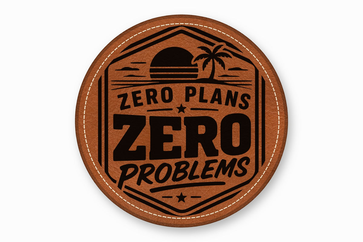 Round brown leather patch with white stitched border, featuring a sunset, palm tree, and text "ZERO PLANS ZERO PROBLEMS".