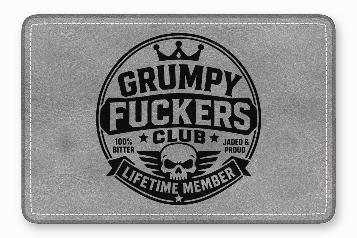 A rectangular grey leather patch features a circular black emblem with a skull and text.