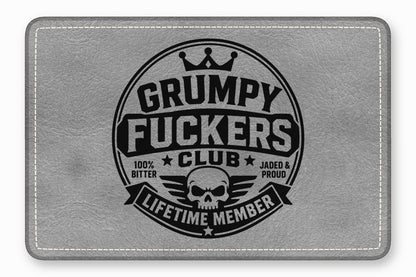A rectangular grey leather patch features a circular black emblem with a skull and text.