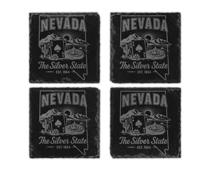 Four slate coasters featuring Nevada symbols: mountains, sun, cactus, playing cards, and roulette wheel.