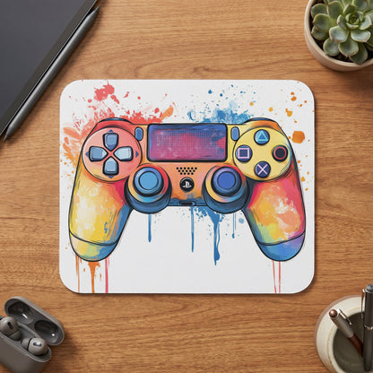 Gaming controller with a colorful watercolor splash design on a white mat.