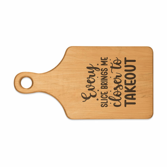 Wooden cutting board with text "Every slice brings me closer to takeout".