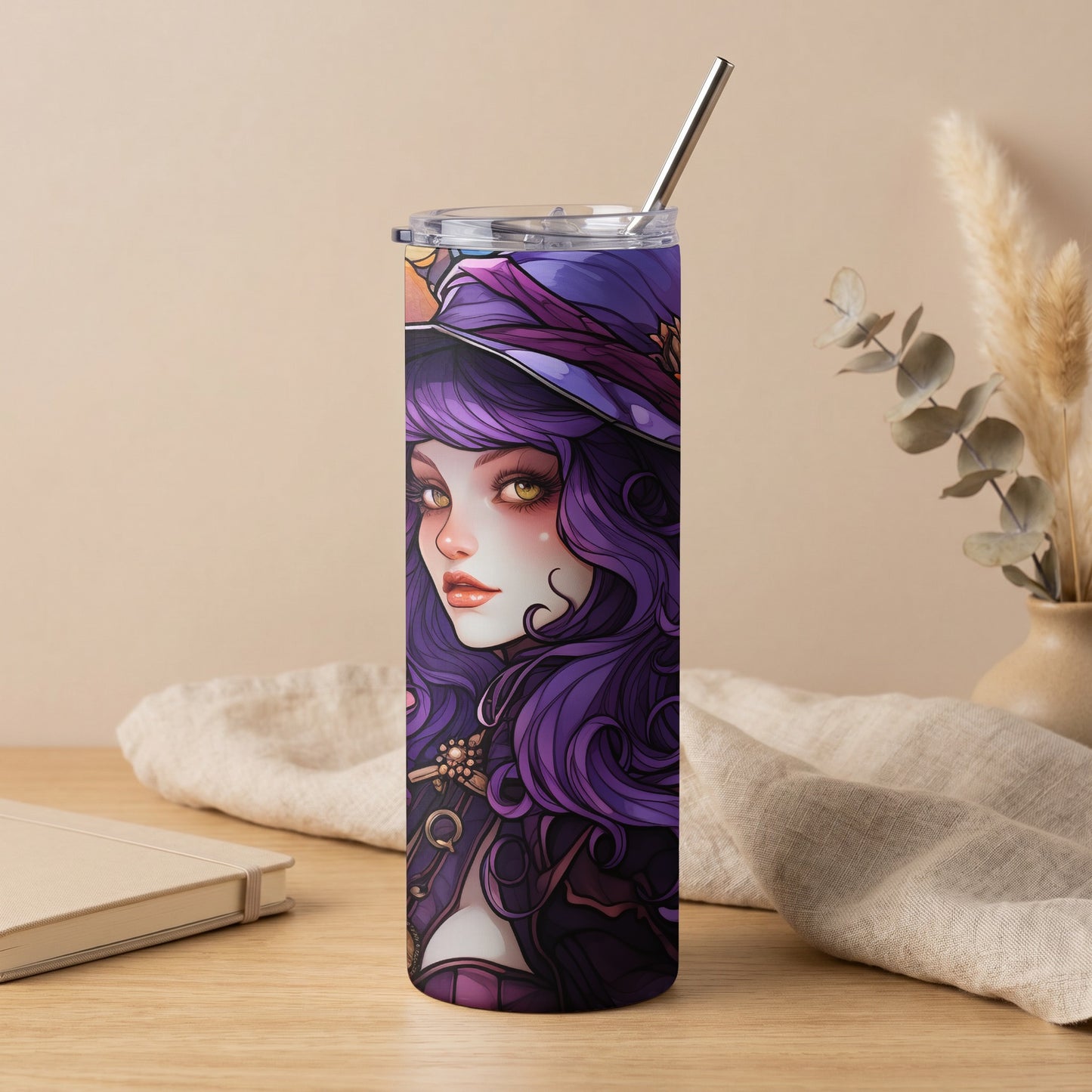 Purple witch illustration on a tall tumbler with a metal straw.