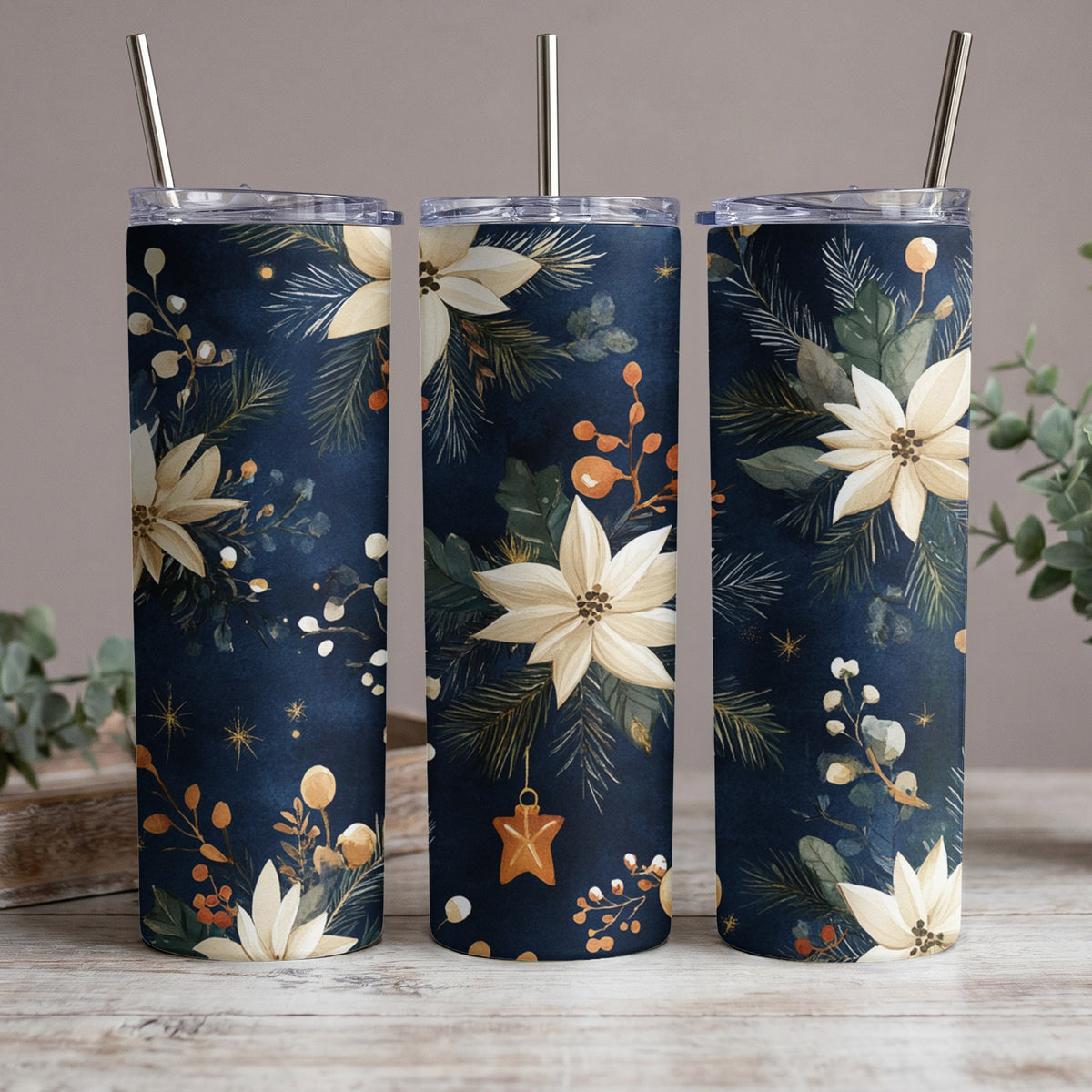 Three tumblers with a dark blue floral and pine needle Christmas design.
