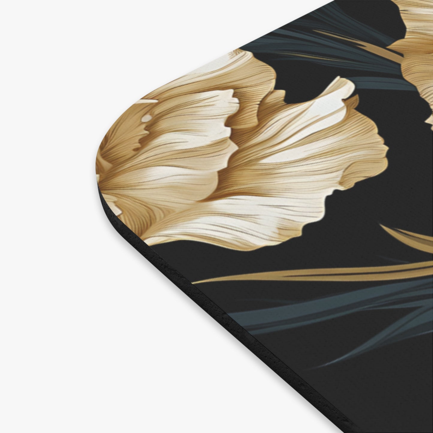 Close-up of a black mat with a golden floral pattern and dark green leaves.