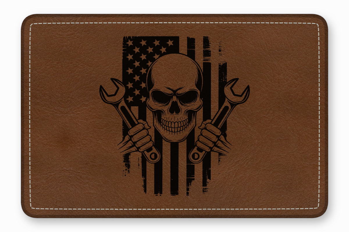 Brown leather patch featuring a black laser-engraved design of a skull, crossed wrenches, and an American flag.