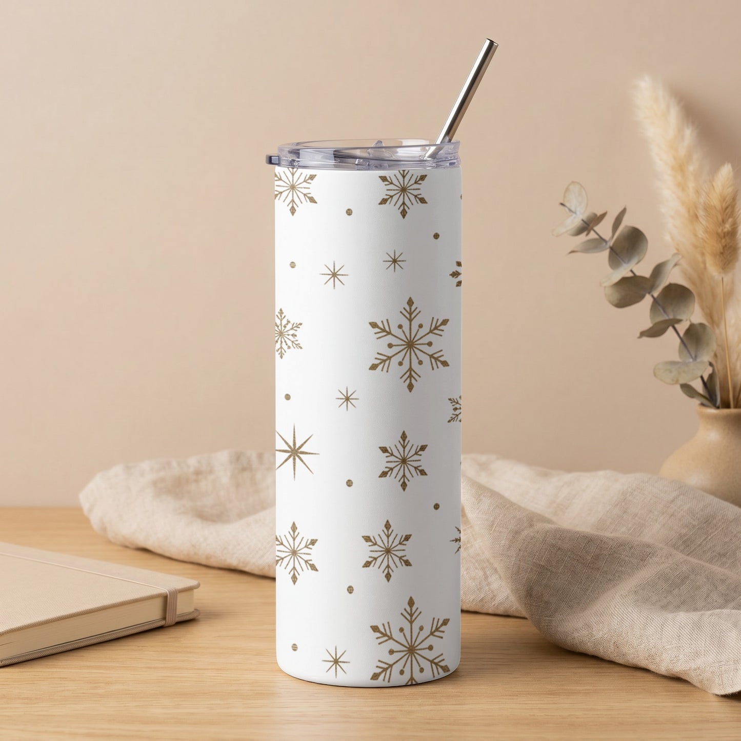 White tumbler with gold snowflake pattern and silver straw.