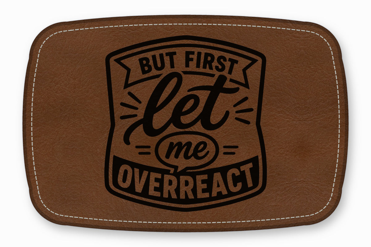 Brown faux leather patch with white stitched border and black text that reads But First Let Me Overreact.