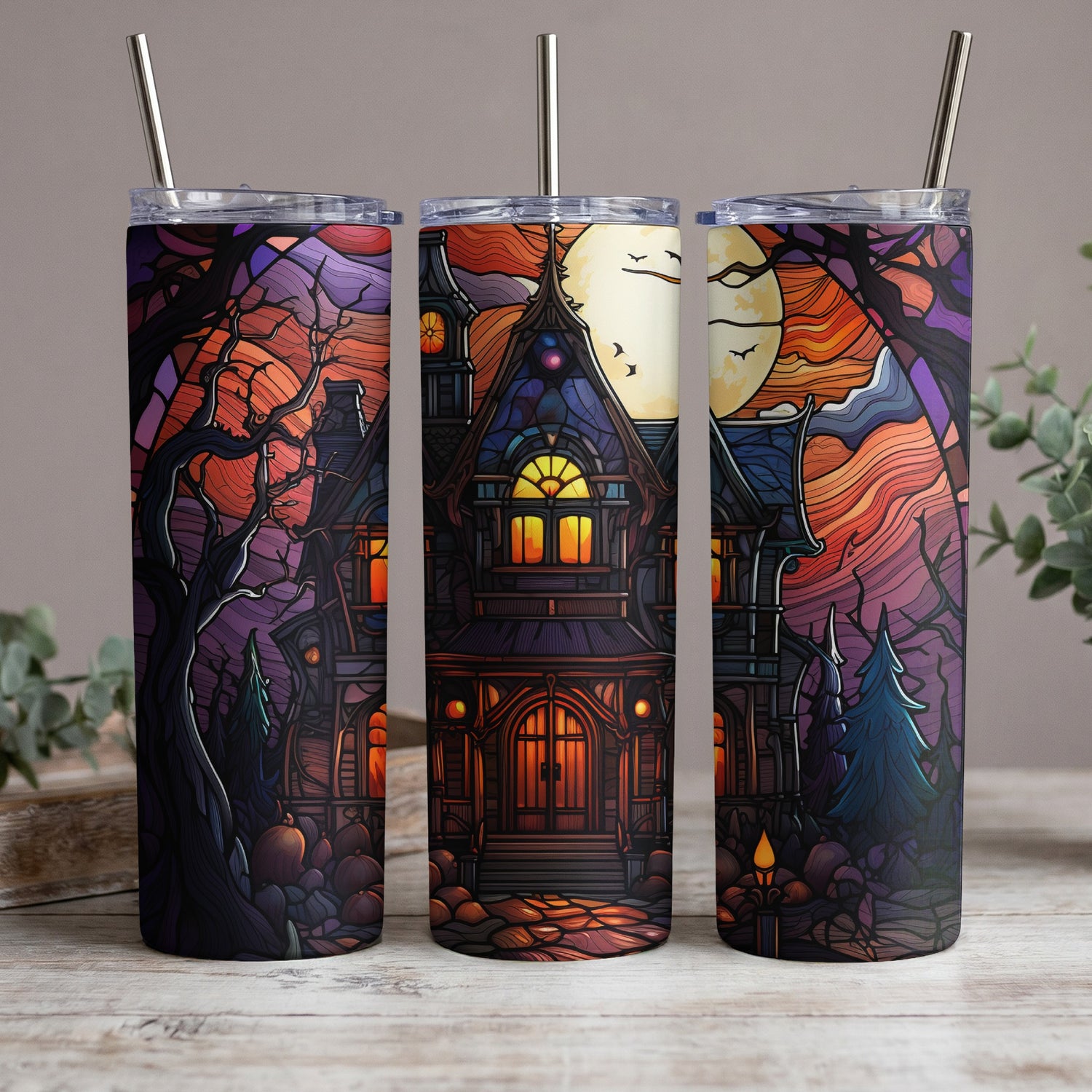Three tumblers with a stained-glass Halloween haunted house and moon design.