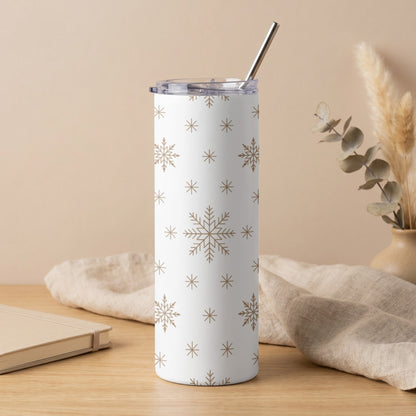 White tumbler with gold snowflake pattern and metal straw.