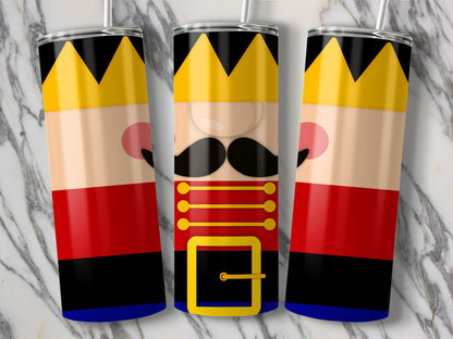 Three nutcracker-themed tumblers with straws on a marble background.