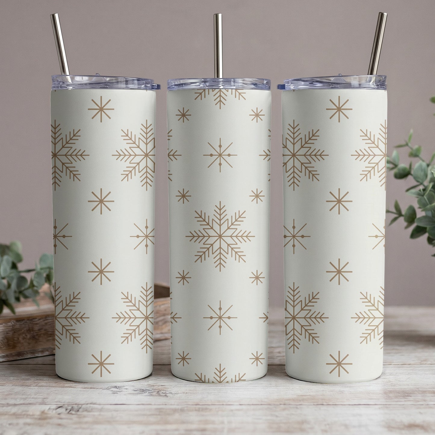 Three tumblers with a light background and a repeating snowflake pattern.