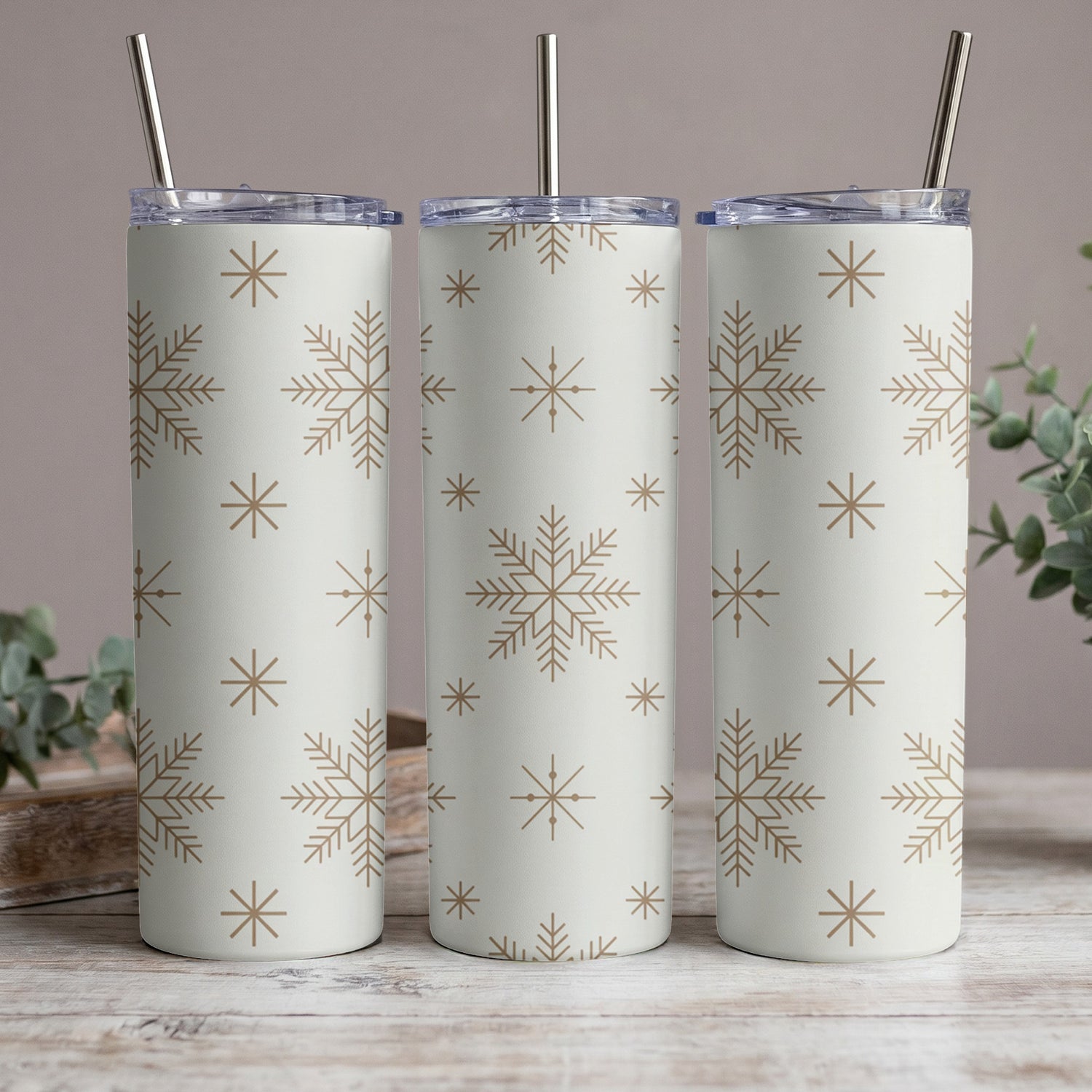 Three tumblers with a light background and a repeating snowflake pattern.